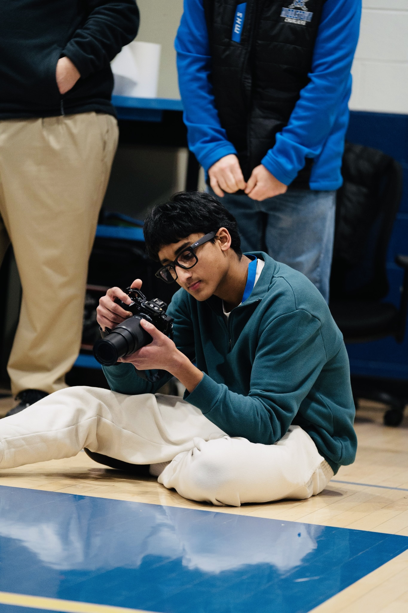 Devkrishna Manappattu photographing a basketball game from the gym floor