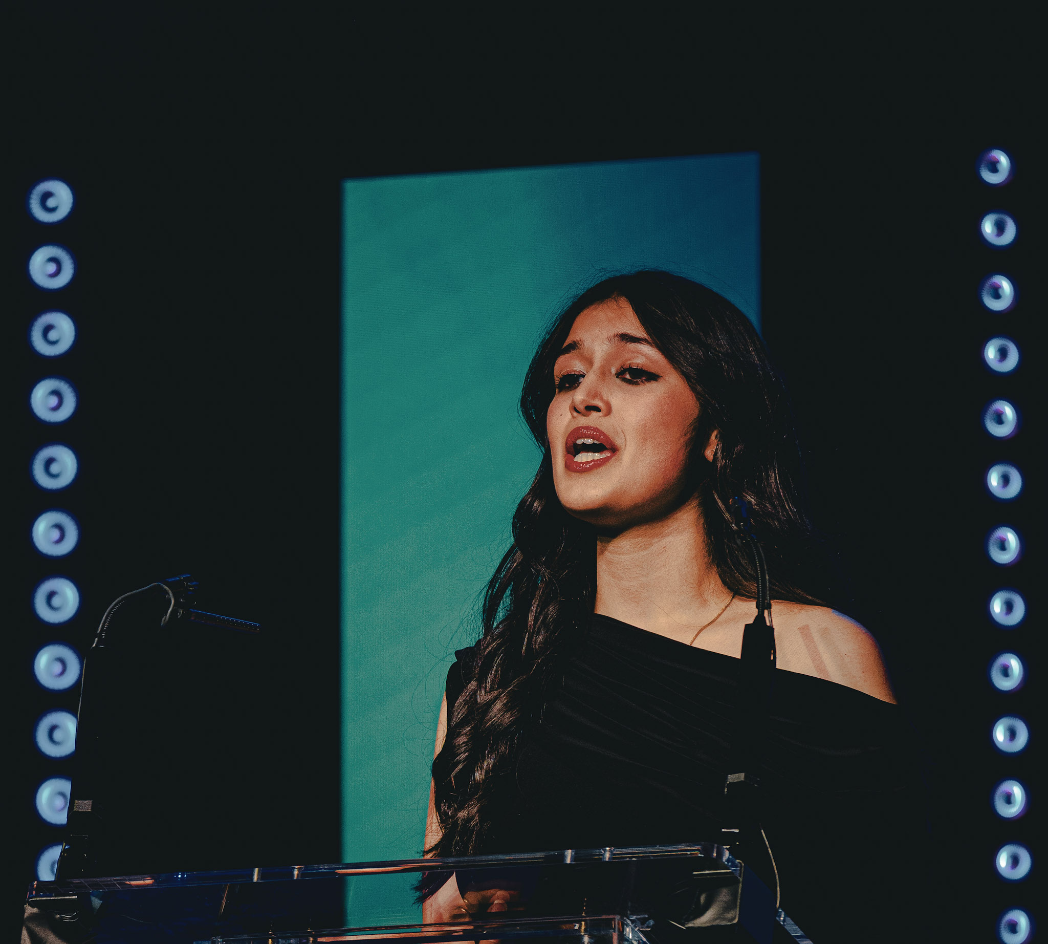 Woman speaking at BPA podium under stage lights