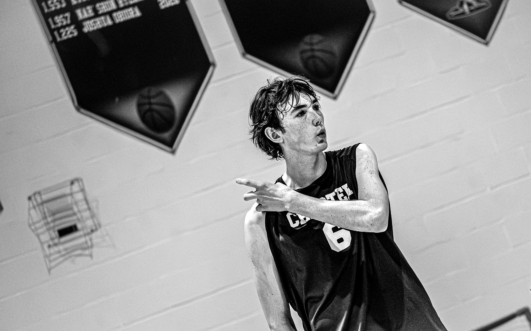 Basketball player in black and white pointing in gymnasium