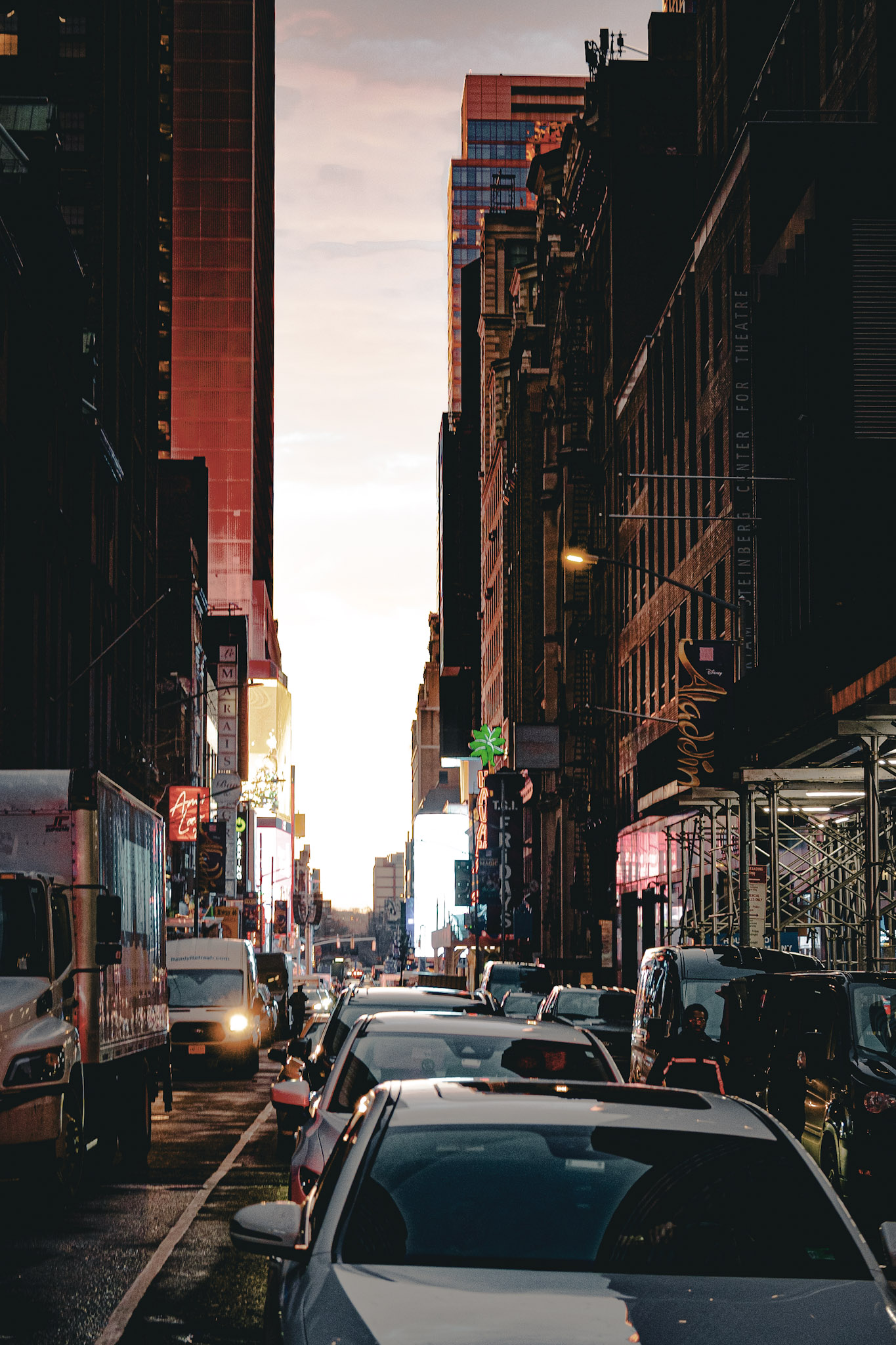 NYC Theater District street at golden hour with traffic