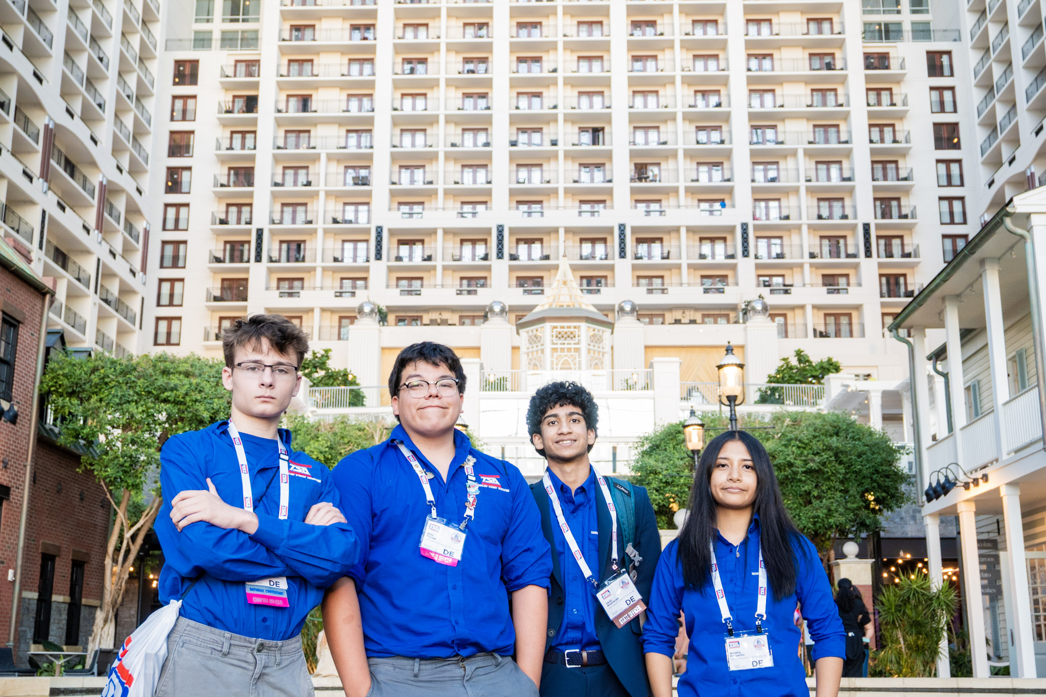 Delaware BPA delegation — four students in blue shirts with conference badges at Gaylord Hotel
