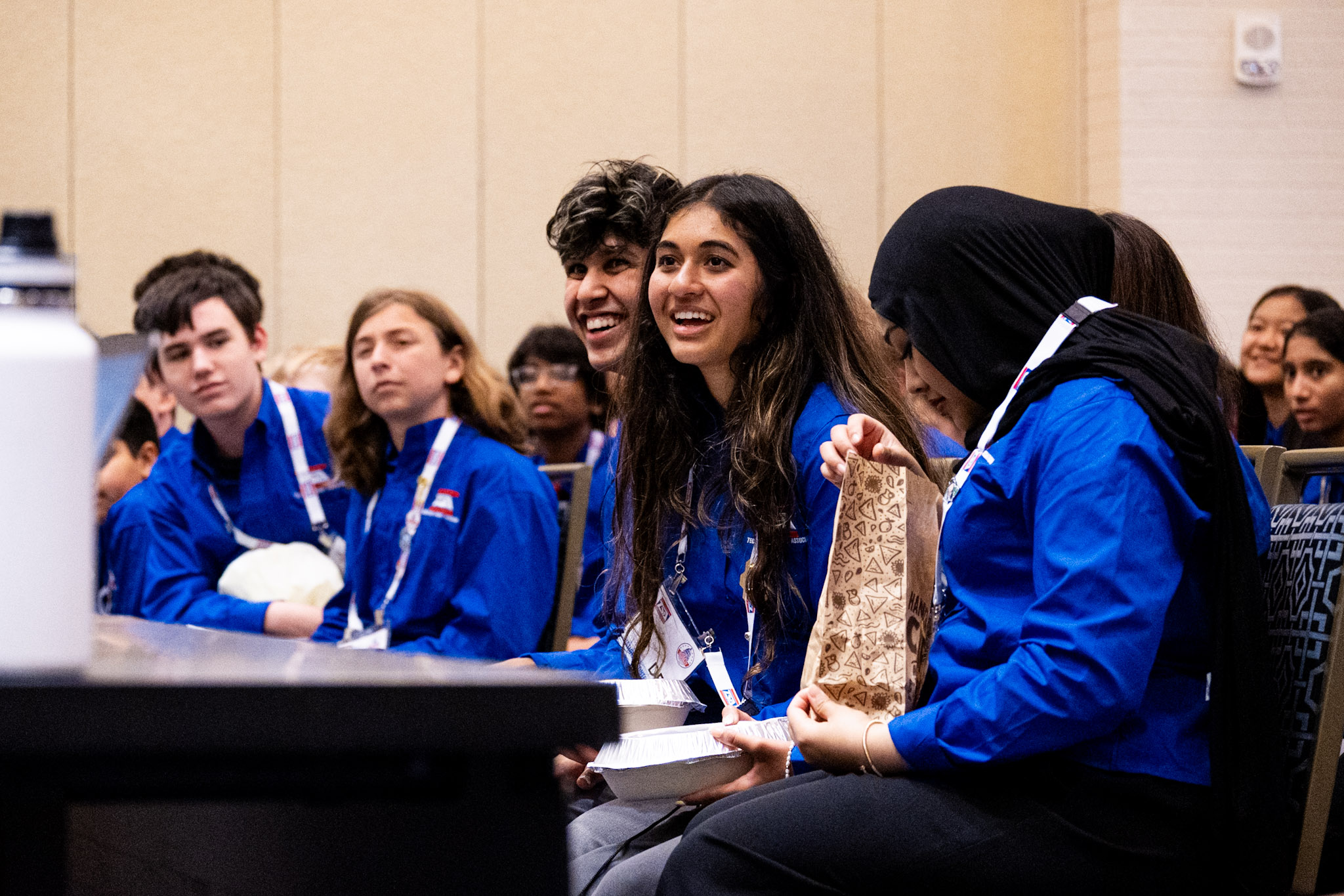BPA conference — students in blue BPA jackets laughing in conference room